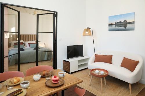 Il comprend un salon doté d'un canapé et d'une table avec une télévision. dans l'établissement Chalet Aux Oiseaux - by La Boite en Plus, à Chantilly