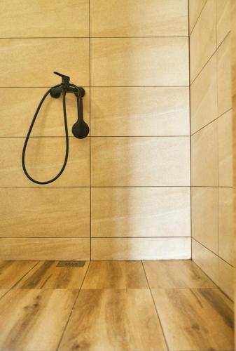 a shower with a black shower head on a wall at RomaOlyaHouse in Budva