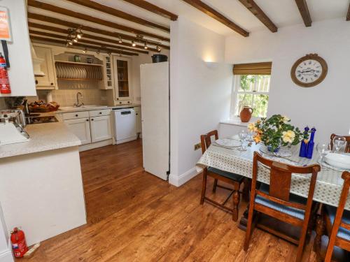 a kitchen with a table and a white refrigerator at The Coach House in Berwick-Upon-Tweed