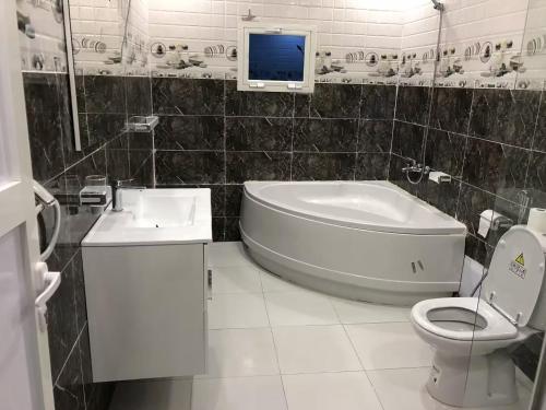 a bathroom with a tub and a toilet and a tv at Appartement spacieux 3 chambres in Nouakchott