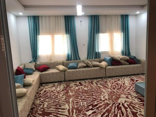 a large couch in a living room with windows at Appartement spacieux 3 chambres in Nouakchott