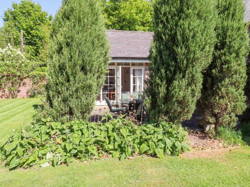 a house with a garden with trees and bushes at The Coach House in Berwick-Upon-Tweed