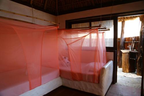 a room with an orange curtain and a couch at Hotel Bahía de la Luna in Arroyo Cruz