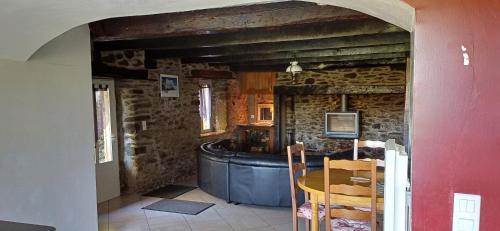 Cette chambre dispose d'une baignoire dans un mur en pierre. dans l'établissement Gîte La Belle Aubrac, à Saint-Côme-dʼOlt