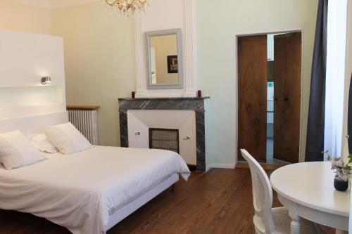 a bedroom with a bed and a table and a mirror at Les loges de la suite in Prades