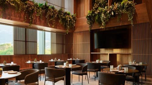 a restaurant with tables and chairs and a flat screen tv at Presidente InterContinental Monterrey by IHG in Monterrey