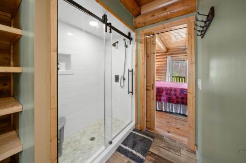 un bagno con doccia in vetro in una casa di legno di A-Frame Cabin with Long Range Mountain Views a Banner Elk