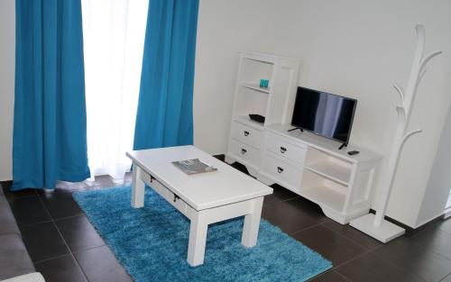 sala de estar con mesa y TV en Yes Pico, en Santa Luzia