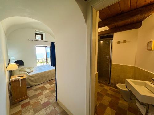 a bathroom with a sink and a bedroom with a bed at Villa Il Frantoio and Lilmar in Praiano