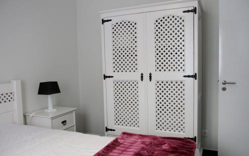 a white bedroom with a bed and a white cabinet at Yes Pico in Santa Luzia