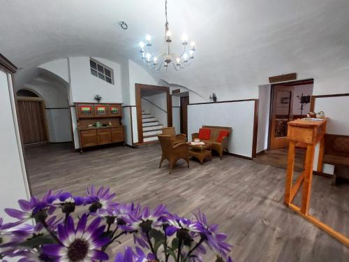 a large living room with a chandelier and purple flowers at Hotel&Restaurant Gasthof zur Post Eisenerz in Eisenerz
