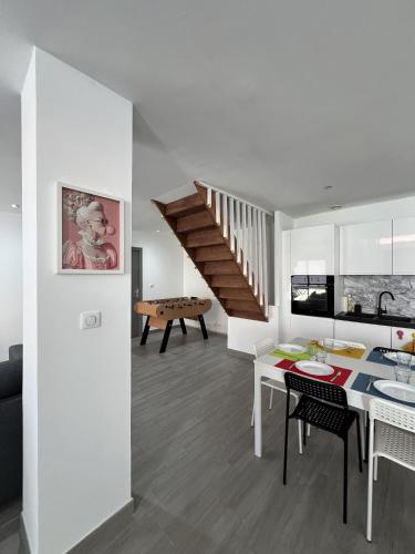 Il comprend une cuisine et un salon avec une table et un escalier. dans l'établissement ValenStay - Maison groupes ou famille - Netflix, à Anzin