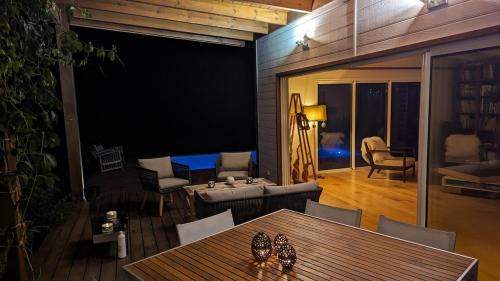 a living room with a table and a living room with a couch at Peaceful house in nature, with views of rolling hills in Bourail