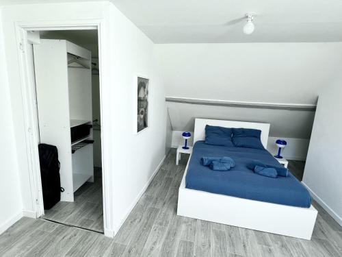 a bedroom with a bed with blue pillows at ValenStay - Maison groupes ou famille - Netflix in Anzin