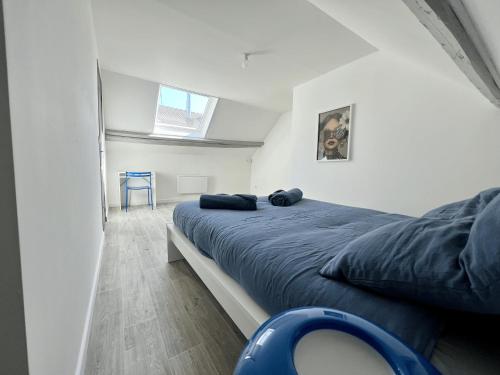 a bedroom with a bed and a blue chair at ValenStay - Maison groupes ou famille - Netflix in Anzin