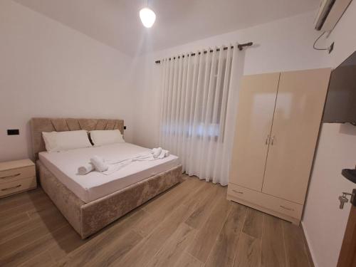 a bedroom with a large bed and a cabinet at Vila Martini in Vlorë
