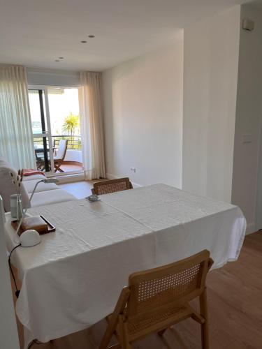 ein Esszimmer mit einem weißen Tisch und Stühlen in der Unterkunft #OcéanoAtlántico in San Vicente do Mar