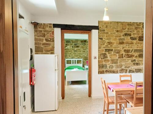a kitchen and dining room with a table and a refrigerator at Casale storico nella campagna cilentana in Rutino