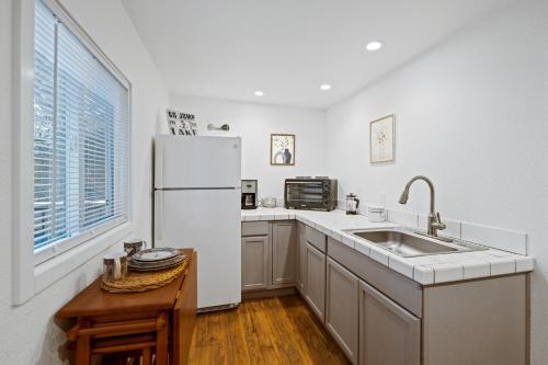 a kitchen with a sink and a white refrigerator at Lakefront, Private dock, ensuite-unit, King bed, Free EV charger, Boat Friendly in Lower Lake