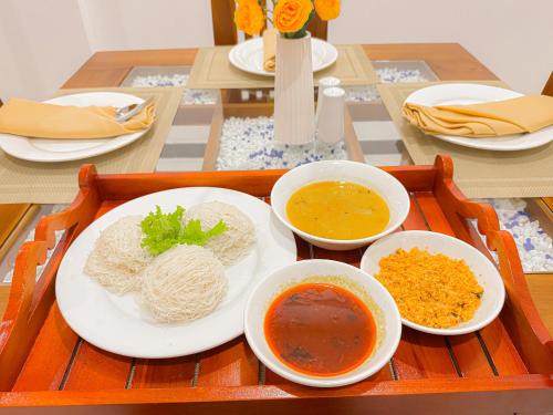 a tray with bowls of food on a table at Shelo Transit Hotel in Katunayake