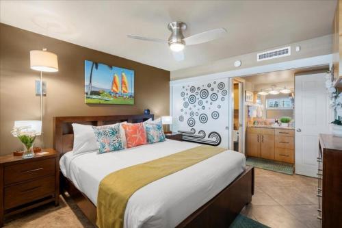 a bedroom with a large bed and a bathroom at Sugar Beach 233 in Kihei