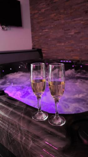 deux verres à vin posés sur une table dans un bain à remous dans l'établissement Le Spa SAJ, à Émiéville