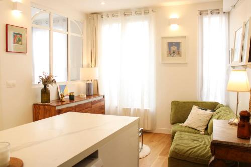 - un salon avec un fauteuil vert et un canapé dans l'établissement Cozy apartment for 2 in the 11th, à Paris