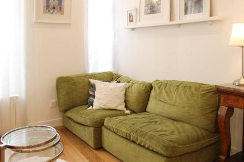 un canapé vert dans un salon avec une table dans l'établissement Cozy apartment for 2 in the 11th, à Paris