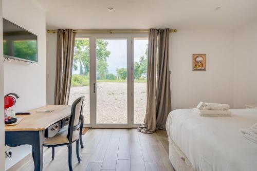 a bedroom with a desk and a bed and a table and chairs at La Réserve du Château de Roques in Puisseguin