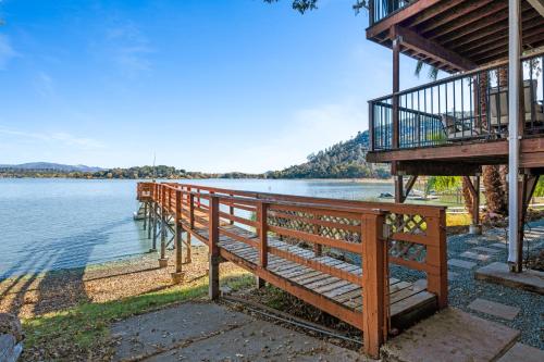 a wooden deck next to a body of water at Lakefront, Private dock, ensuite-unit, King bed, Free EV charger, Boat Friendly in Lower Lake