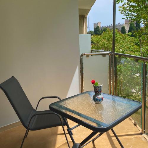 a glass table and a chair on a balcony at SEAL of Deer - Castle View - 5 minute walk to the Beach in Rhodes Town