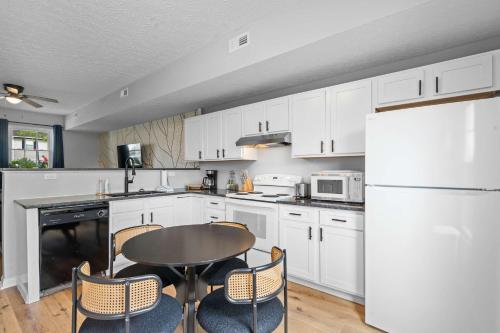 ウィリアムズタウンにあるApartment near Ark for 6 Guests - with Free Parkingの白いキャビネットとテーブルと椅子のあるキッチン