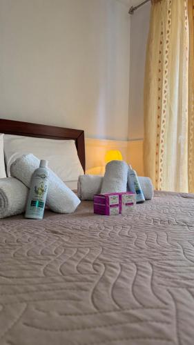 a bed with two bottles of shampoo and towels on it at Vistas Venecianas Corfu in Corfu
