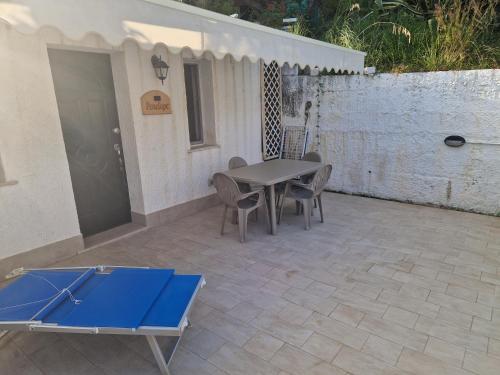a ping pong table and chairs on a patio at Itaca Rooms Palinuro in Palinuro