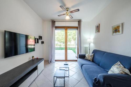 a living room with a blue couch and a tv at B3- Le Magnolie vicino a Bologna Fiera, Lugo Hospital Villa Maria, Ravenna in SantʼAgata sul Santerno