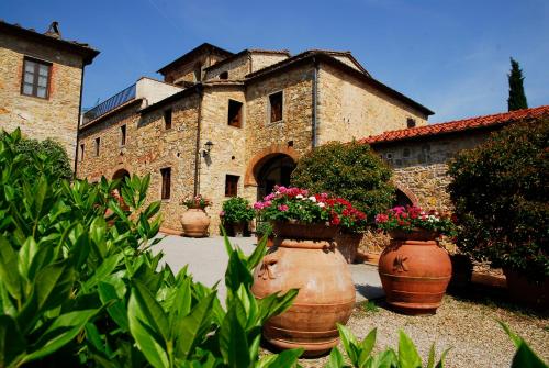 a group of large clay pots with flowers in front of a building at Tenuta Lupinari in Bucine