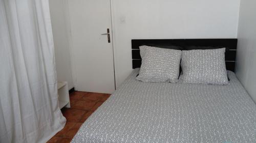 un lit avec deux oreillers dessus dans une chambre dans l'établissement Agréable T2, calme à la plage, RDC, Parking privé, à Canet