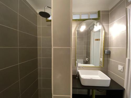 une salle de bain avec un lavabo et un miroir dans l'établissement Agréable T2, calme à la plage, RDC, Parking privé, à Canet