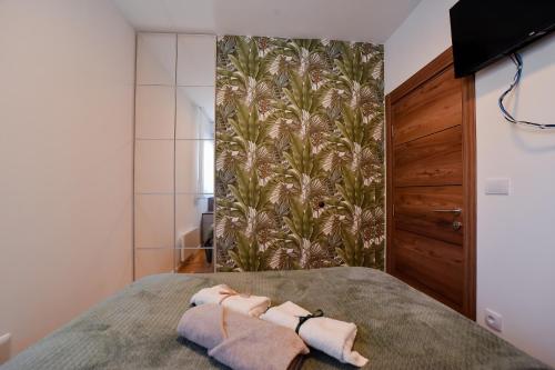 a bedroom with two towels on a bed at Apartman Hedona Zlatibor in Zlatibor