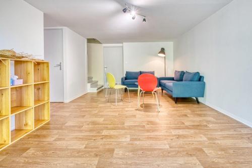 a living room with chairs and a blue couch at le logis des remparts in Périgueux