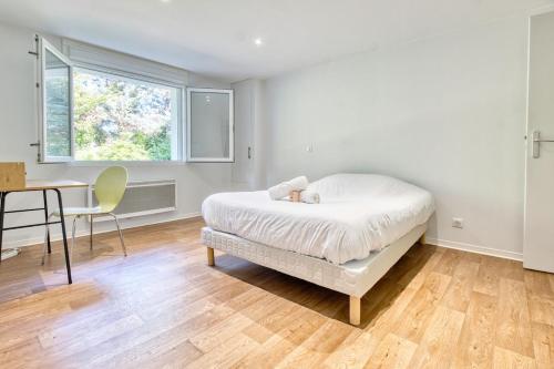 a bedroom with a bed and a table and a window at le logis des remparts in Périgueux