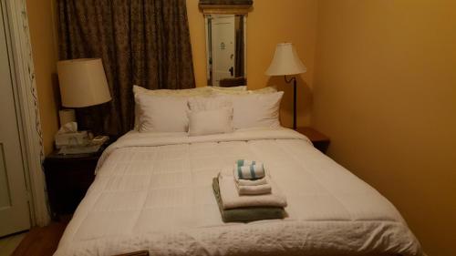 a bedroom with a white bed with towels on it at The Empire House Hotel and Restaurant in Gilbertsville
