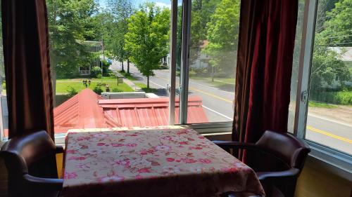 a table and chairs in front of a window at The Empire House Hotel and Restaurant in Gilbertsville