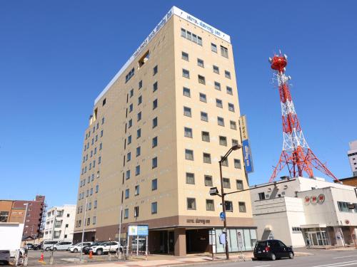 a tall building with a crane on top of it at Dormy Inn Asahikawa in Asahikawa