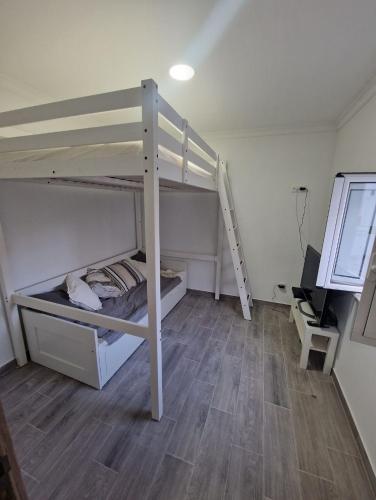 a room with two bunk beds and a desk at Little Paradise in Castro Marim