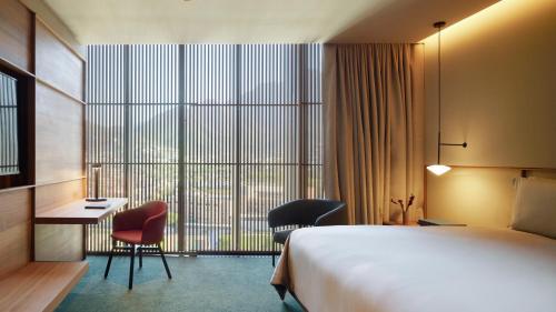 a hotel room with a bed and a desk and chairs at Presidente InterContinental Monterrey by IHG in Monterrey