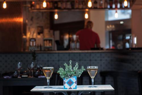 a table with two wine glasses and a vase of flowers at Pointe Isabelle in Chamonix-Mont-Blanc