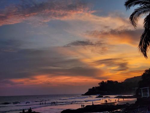 a group of people on the beach at sunset at LOOKING2GOOD in El Zonte