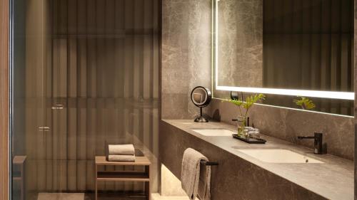 a bathroom with a sink and a mirror and a shower at Presidente InterContinental Monterrey by IHG in Monterrey