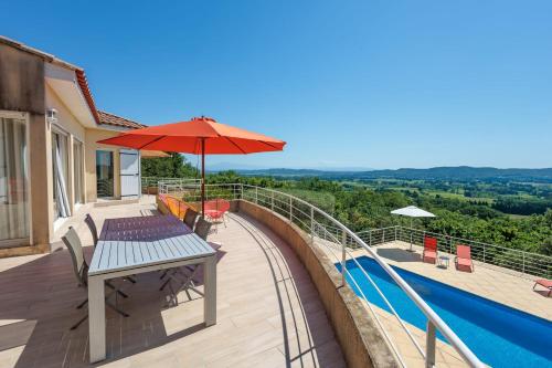 - une terrasse avec une table et un parasol à côté de la piscine dans l'établissement Villa Rochefort - Welkeys, à Rochefort-du-Gard
